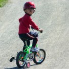 Helmeted_boy_on_training_wheels